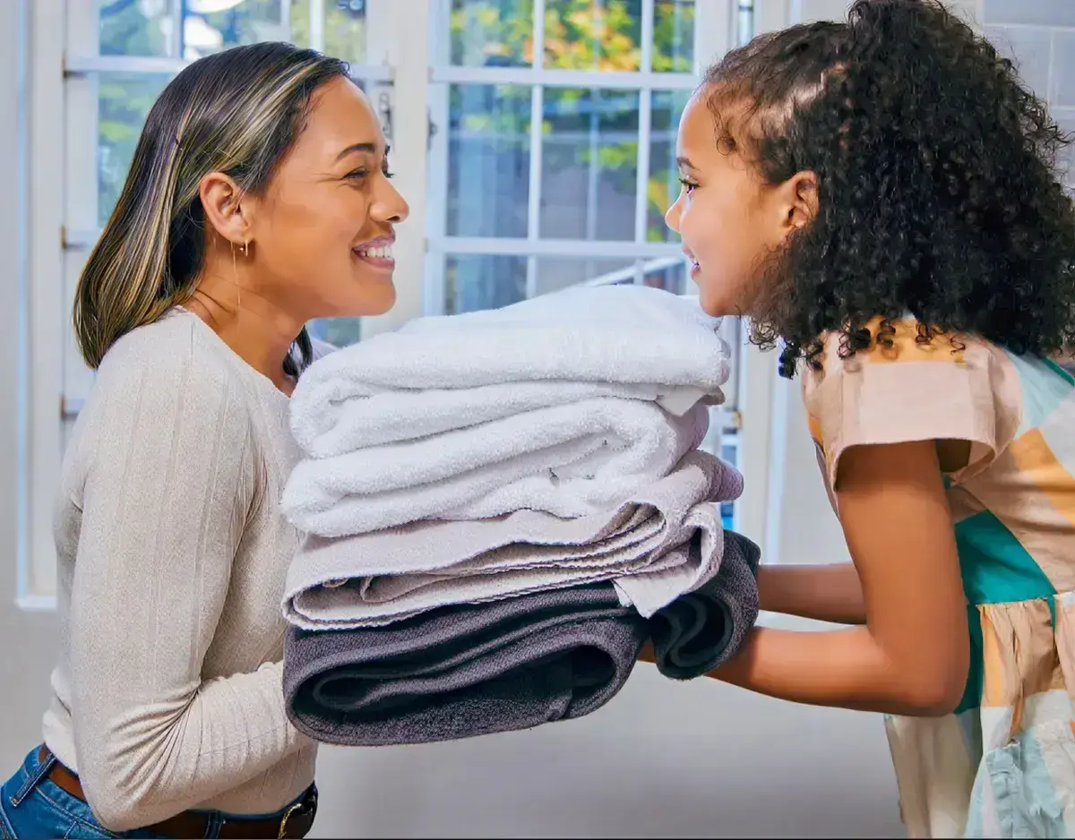 Professional laundry service - person holding neatly folded, clean clothes from NoScrubs laundry delivery in Austin and Houston